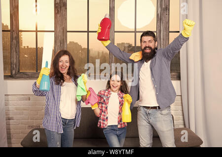 Spring cleaning. Your one stop for home cleaning needs. Happy family hold cleaning products. Mother, father and daughter clean house in spring. Ready for spring. Cleaning home before spting. Stock Photo