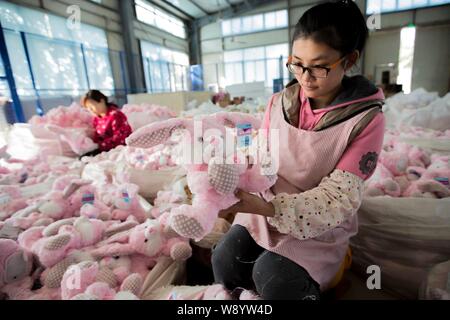 --FILE--Female Chinese workers sew stuffed toys to be exported to Europe and the United States at a garment factory in Ganyu Economic Development Area Stock Photo