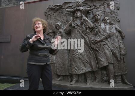 Wartime refugee Sonja Muhlberger, 75, poses for photos in front of the statue of six Jewish people at the Shanghai Jewish Refugees Museum in Shanghai, Stock Photo
