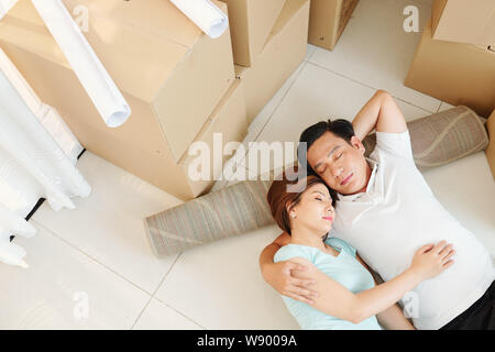 Hugging couple resting on the floor Stock Photo