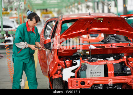 --FILE--A female Chinese worker assembles a car on the assembly line at ...