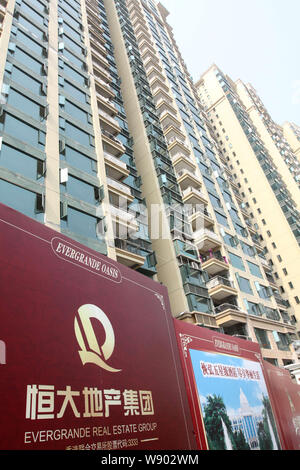 --FILE--An advertisement for Evergrande Real Estate Group is pictured in front of newly-built high-rise apartment buildings in Yichang city, central C Stock Photo