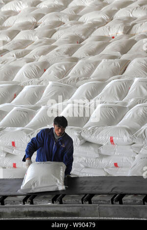 --FILE--A Chinese worker unloads a sack of urea from the conveyor belt at a chemical fertilizer plant of CNPC (China National Petroleum Corporation) i Stock Photo