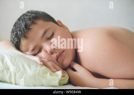 cute fat little kid lying in bed on pillow deep sleeping daytime Stock Photo