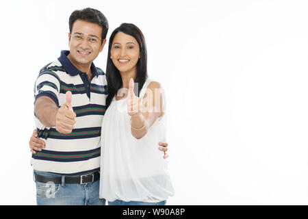 Couple showing thumbs up sign and smiling Stock Photo