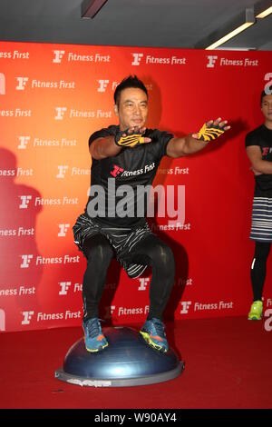 Hong Kong actor Simon Yam squats during the opening event for a fitness club in Hong Kong, China, 19 May 2014. Stock Photo