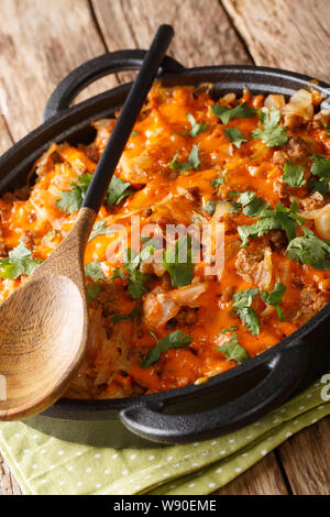 baked cabbage with ground beef, onions and cheese close-up in a pan on the table. vertical Stock Photo