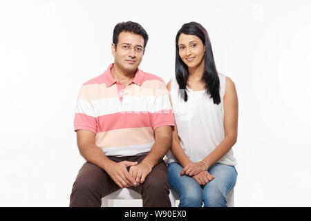 Couple sitting on stool Stock Photo