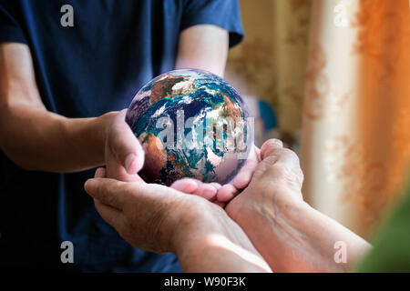 old and young person's hands holding planet earth, unity concept. elements of this images furnished by nasa Stock Photo