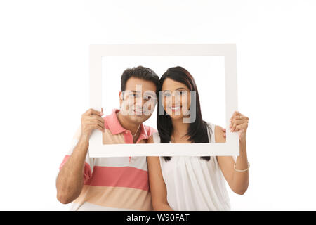 Couple holding frame Stock Photo