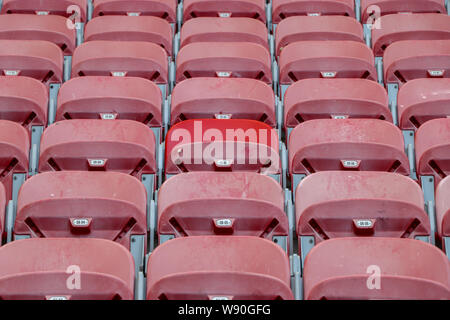 Stadium completely empty hours before the match. Red chairs in which no one is seated. Stock Photo