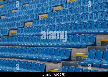 Stadium completely empty hours before the match. Blue chairs in which no one is seated. Stock Photo