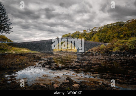 Clachan Bridge, a stone, single arch bridge, built in 1793 and known as the Bridge over the Atlantic, spans Clachan Sound between mainland Scotland an Stock Photo