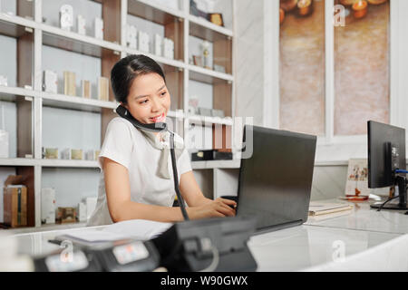 Receptionist talking on phone Stock Photo