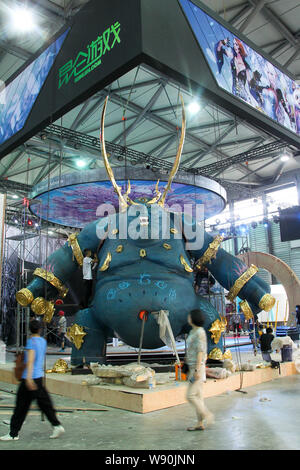 --FILE--Visitors walk past a giant model of a character from an electronic game at the stand of Kunlun.com before the opening of the 12th China Digita Stock Photo