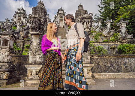 Happy couple of tourists on background of Three stone ladders in beautiful Pura Lempuyang Luhur temple. Summer landscape with stairs to temple Stock Photo