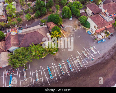 Aerial view of Amed beach in Bali, Indonesia. Traditional fishing boats called jukung on the black sand beach and Mount Agung volcano in the Stock Photo