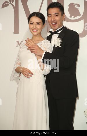 Chinese actress Gao Yuanyuan, left, and her Taiwanese actor husband Mark Chao show their wedding rings during their wedding banquet in Taipei, Taiwan, Stock Photo