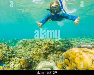 Happy woman in snorkeling mask dive underwater with tropical fishes in coral reef sea pool. Travel lifestyle, water sport outdoor adventure, swimming Stock Photo