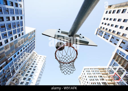 Low angle view at basketball hoop in urban background, copy space Stock Photo