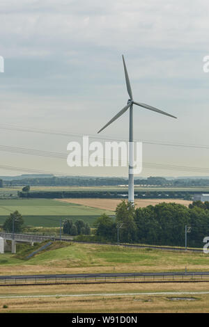 Windmills as wind turbine power generators placed within the countryside of green country of Netherlands. Stock Photo