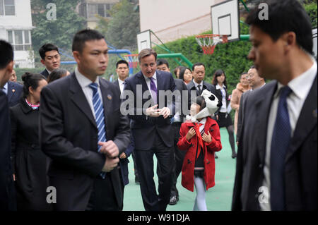 British Prime Minister David Cameron, center, talks with a young Chinese student during his visit to a primary school in Chengdu city, southwest China Stock Photo