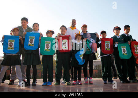 American basketball player Stephon Marbury of Chinas Beijing Ducks, center tallest, poses with Chinese students and presents he gives to them during h Stock Photo