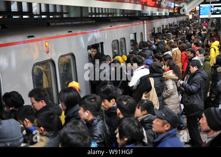 --FILE--A crowd of passengers queue up to enter a metro train at a subway station during the rush hour in Beijing, China, 25 January 2013.   Beijings Stock Photo