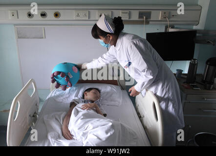 A Chinese nurse attends the 6-year-old boy infected with the H7N9 avian flu virus at Ditan Hospital in Beijing, China, 29 May 2013.   Health authoriti Stock Photo