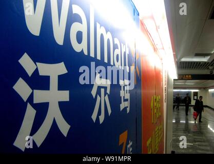 --FILE--People walk past an advertisement of Wal-Mart in Shanghai, China, 5 April 2011.   Wal-Mart Stores Inc. is investing 100 million yuan ($16.3 mi Stock Photo
