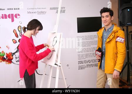 South Korean actress Ku Hye Sun, left, is drawing a portrait of Hong Kong actor Aarif Lee at the opening event for her solo art exhibition, After Imag Stock Photo