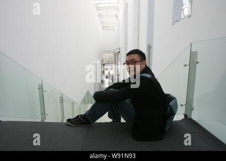 --FILE--Chinese artist Wang Jianwei poses next to one of his artworks ...
