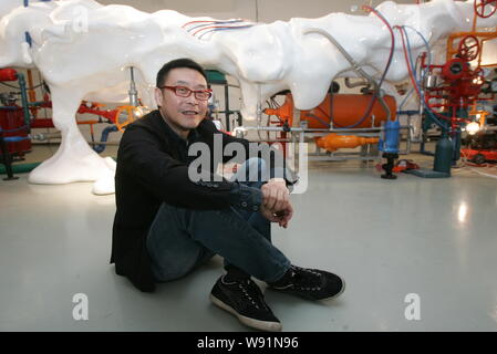 --FILE--Chinese artist Wang Jianwei poses next to one of his artworks ...