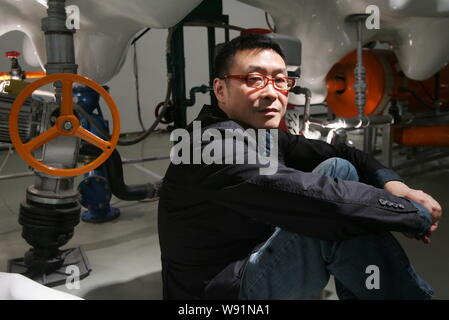 --FILE--Chinese artist Wang Jianwei poses next to one of his artworks ...