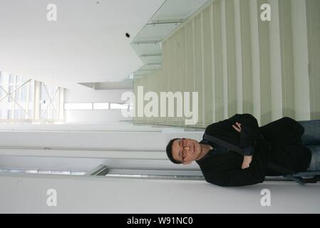 --FILE--Chinese artist Wang Jianwei poses next to one of his artworks ...