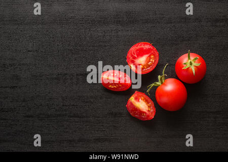 Sliced red tomatoes on black table. Top view. Stock Photo