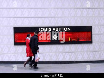 FILE--Pedestrians walk past a Louis Vuitton (LV) store in Chongqing, China,  23 November 2015. French luxury goods firm Louis Vuitton is seeking da  Stock Photo - Alamy