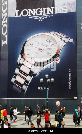 FILE Pedestrians walk past an advertisement for luxury watch