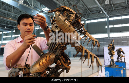 A Chinese fan examines and tests a robot made from auto scraps in the shape of a figure from the movie series, Transformer, at Hefei Binhu Internation Stock Photo