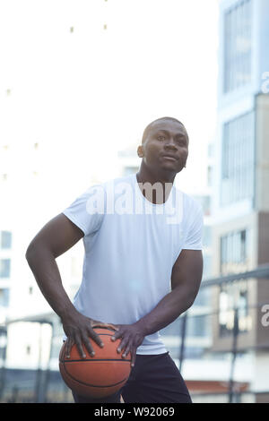 Portrait of muscular African man playing basketball in urban setting Stock Photo