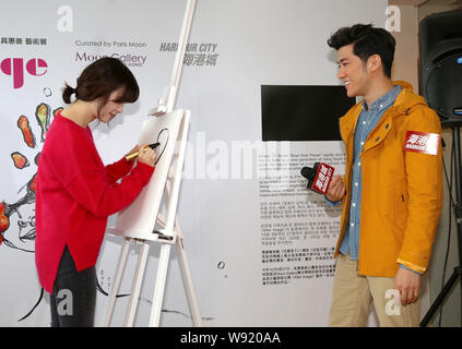South Korean actress Ku Hye Sun, left, is drawing a portrait of Hong Kong actor Aarif Lee at the opening event for her solo art exhibition, After Imag Stock Photo