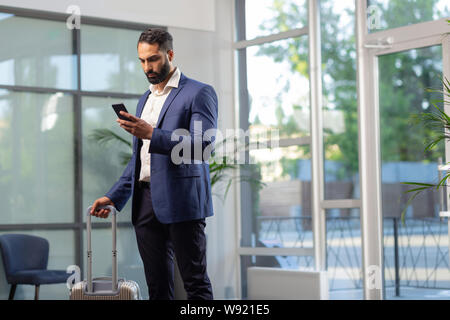 Serious bearded male person checking his email Stock Photo