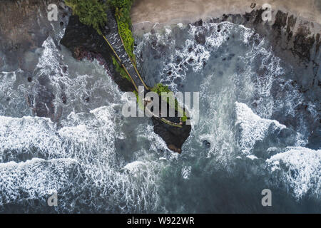 Aerial view of famous balinese temple Tanah Lot in stormy weather with huge crashing waves. Top Indonesian landmark Stock Photo