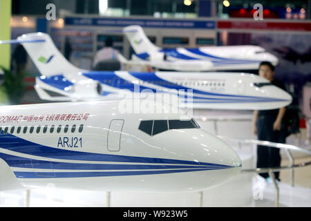 --FILE--Visitors look at models of the Chinese-developed ARJ21 regional jet of COMAC (Commercial Aircraft Corporation of China, Ltd.) during the 2011 Stock Photo