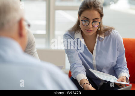 Attentive brunette woman looking at pale of documents Stock Photo