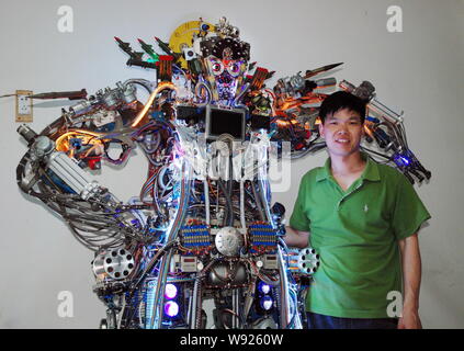 Chinese farmer Tao Xiangli poses with his robot made from scrap at home in Beijing, China, 16 May 2013.   Tao Xiangli, a 37-year-old inventor from Bei Stock Photo