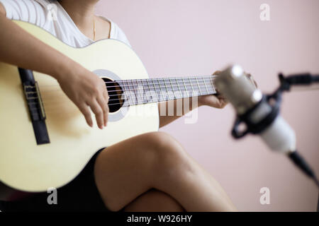 Asian woman play acoustic classic guitar for jazz and easy listening song and record with microphone select focus shallow depth of field Stock Photo