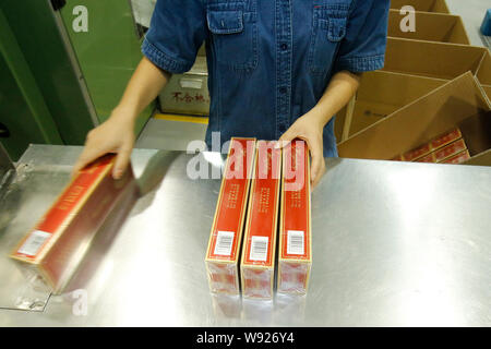 china tobacco zhejiang industrial co ltd --FILE--A worker handles cartons of cigarettes at an assembly line at a  tobacco factory of Hubei China Tobacco Industry Co., Ltd. in Hubei Enshi  Econo Stock Photo