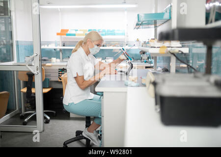 Dental technician working on cast model of teeth. Stock Photo