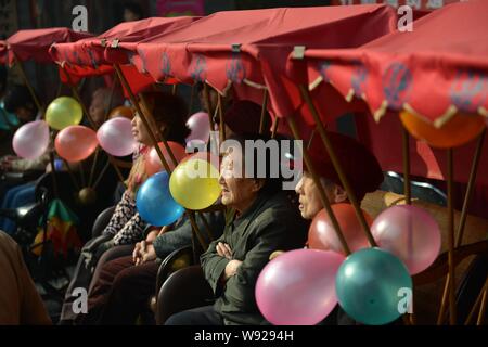 --FILE--Elderly Chinese residents sit in rickshaws as they tour hutongs in Beijing, China, 20 October 2012.   Beijing is faced with rapid growth in it Stock Photo